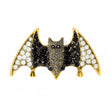 Bat brooch with black and white faceted stones on gold-tone base, cutout on white.