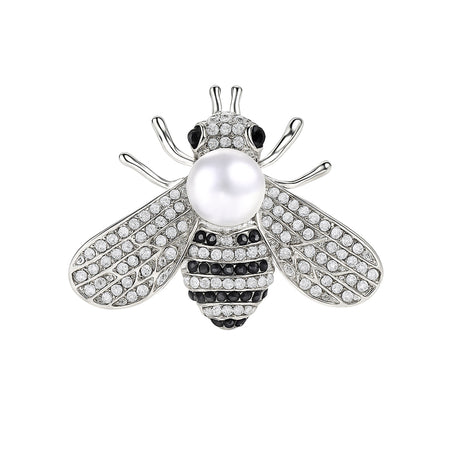 Bee brooch with silver-tone finish, clear faceted stones, black accents, and white round bead, cutout on white background.