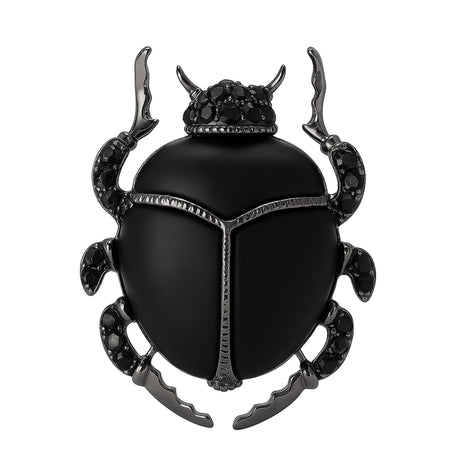 Beetle brooch with matte black body, dark metallic legs, and black faceted stones, cutout on white background.