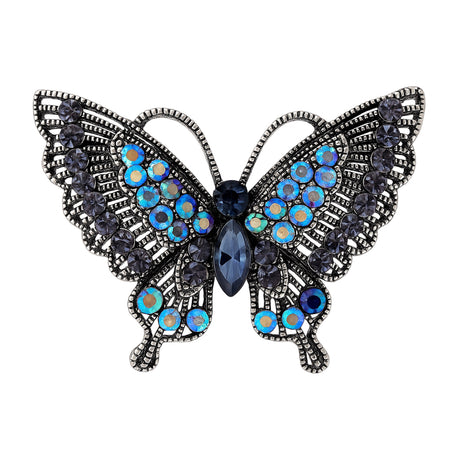 Butterfly brooch with dark metal base, black faceted stones with iridescent blue accents, cutout on white background.