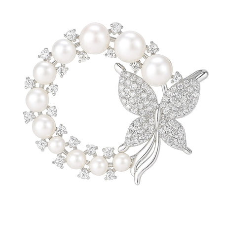 Butterfly brooch with silver-tone metal, white round imitation pearls, and clustered clear stones in a circle shape, cutout on white.