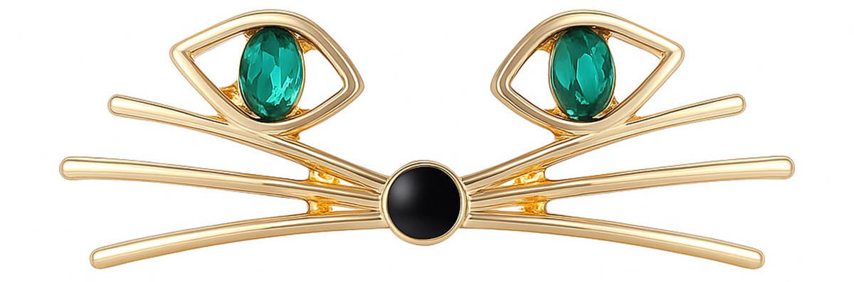 Cat face brooch with gold-tone metal, green oval stones for eyes, and black round nose, cutout on white. Landscape crop for secondary use.