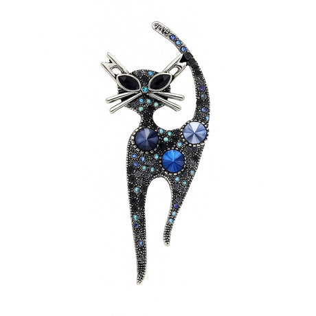 Cat brooch with vintage-inspired silver-tone metal base, blue faceted stones, and black oval eyes, cutout on white.