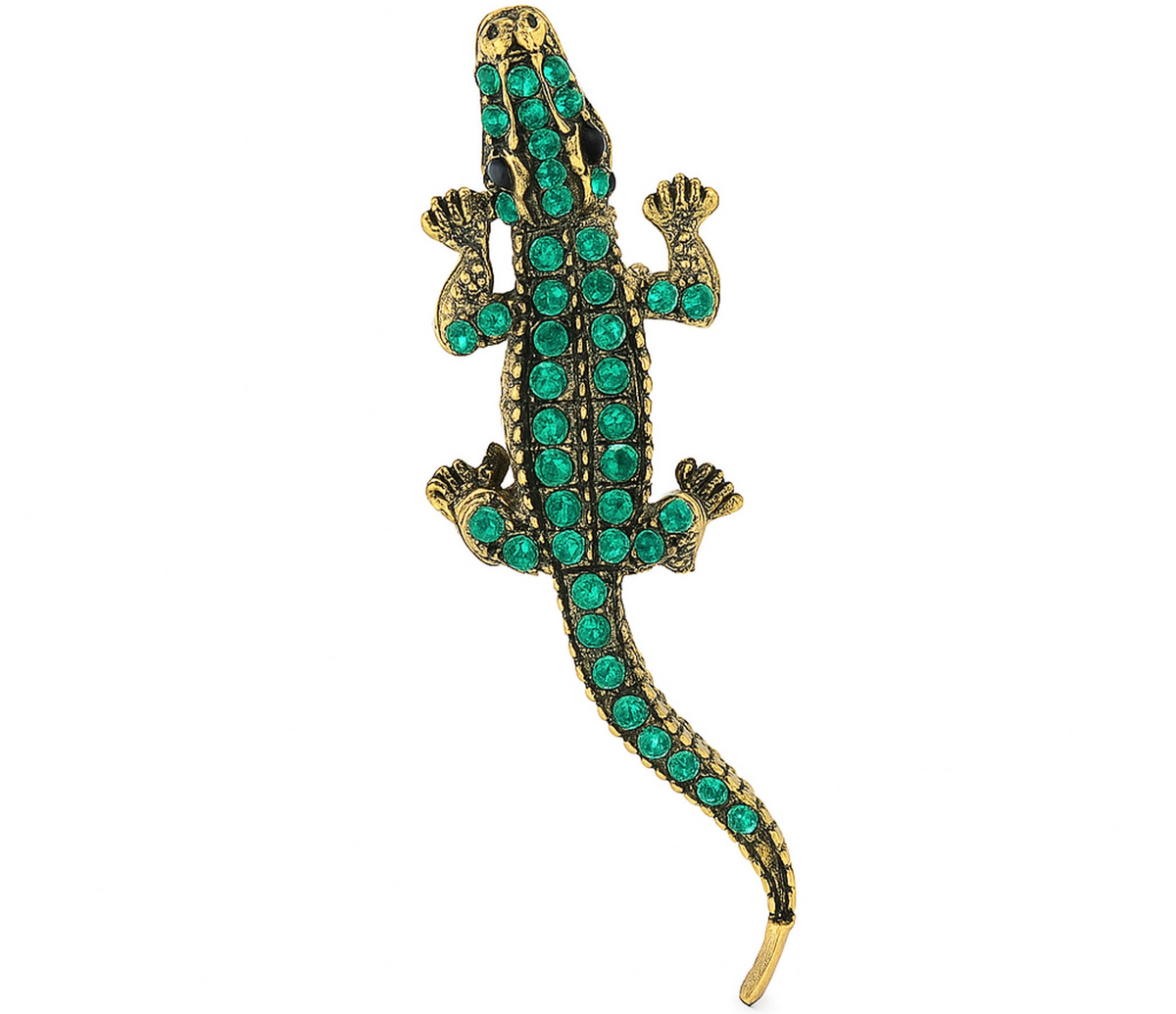 Lizard brooch with gold-tone metal base and green faceted stones, top-down view, cutout on white background. Landscape crop for secondary use.