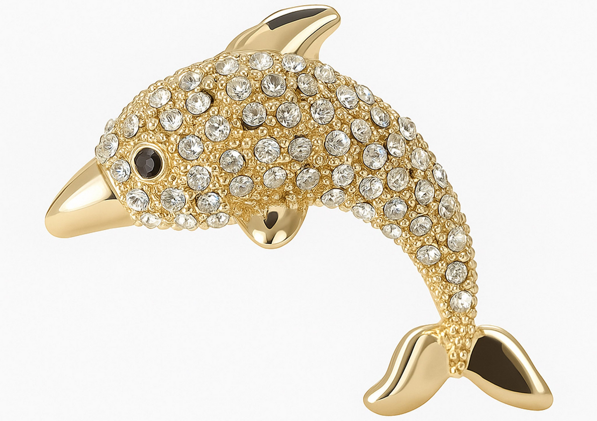 Dolphin brooch with polished gold-tone finish and clear faceted stones, cutout on white background. Landscape crop for secondary use.