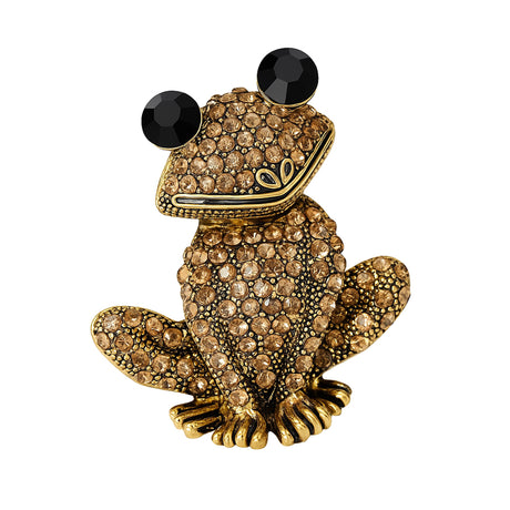Frog brooch in gold-tone metal with clustered beige faceted stones and black round eyes, cutout on white background.