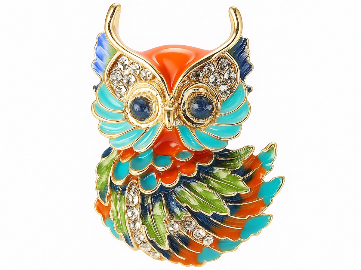 Owl brooch with gold-tone outline, orange and turquoise enamel accents, green and navy feather details, clear faceted stones, and round blue eyes, cutout on white. Landscape crop for secondary use.