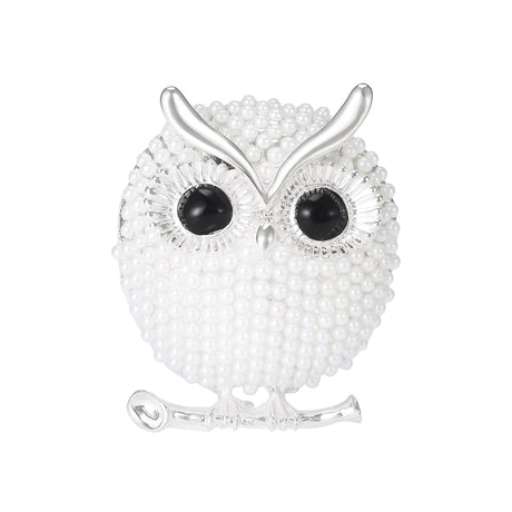 Owl brooch with silver-tone finish, white round beads, black gem-like eyes, and perch design, cutout on white background.