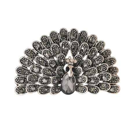 Peacock brooch with black faceted stones and silver-tone base, teardrop center stone, cutout on white.