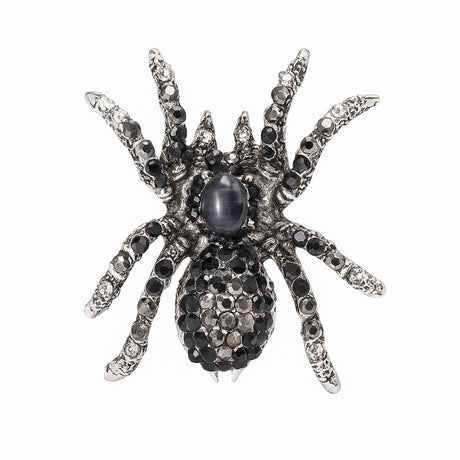 Tarantula brooch with silver-tone base, black and clear faceted stones, and a dark oval cabochon center, cutout on white.