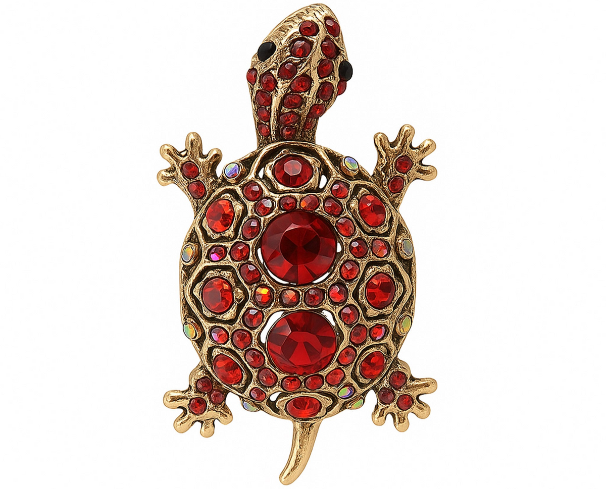 Tortoise brooch with gold-tone metal finish, red faceted center stones, and round red accents, cutout on white. Landscape crop for secondary use.