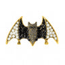 Bat brooch with black and white faceted stones on gold-tone base, cutout on white.