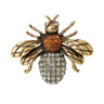 Bee brooch featuring antique gold-tone wings, orange-brown faceted stones on top part of body, and clear clustered stones on bottom, cutout on white.