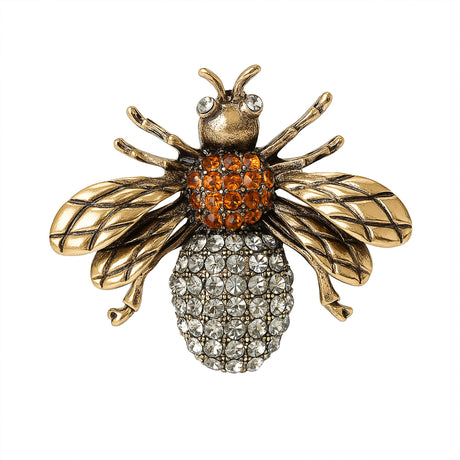 Bee brooch featuring antique gold-tone wings, orange-brown faceted stones on top part of body, and clear clustered stones on bottom, cutout on white.