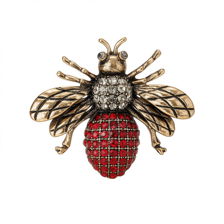 Bee brooch with antique gold-tone wings, clear stones on thorax, and red clustered stones on oval bottom part of body, cutout on white.