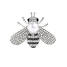 Bee brooch with silver-tone finish, clear faceted stones, black accents, and white round bead, cutout on white background.