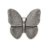 Butterfly brooch with silver-tone finish, black etched swirl wings, and clear teardrop stone, cutout on white.