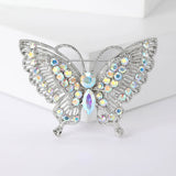 Butterfly brooch with silver-tone base, iridescent round and marquise-cut stones, front view on white block.