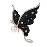 Butterfly brooch with black wings, clear faceted stones, star accents, and pearl detail, cutout on white background.