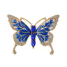 Butterfly brooch with blue and white enamel wings, gold-tone outline, clear faceted wing stones, and three oval blue faceted stones forming the body, cutout on white.