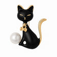 Cat brooch with black enamel body, gold-tone accents, white round faux pearl, and bow detail, cutout on white background.