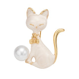 Cat brooch with white enamel body, gold-tone edges, white round imitation pearl, and bow charm, cutout on white background.
