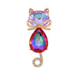 Cat brooch with iridescent pink-purple faceted stones, gold-tone bow accent, and curled tail with clear stones, cutout on white.