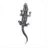 Lizard brooch with silver-tone metal finish and black faceted stones, top-down view, cutout on white background.