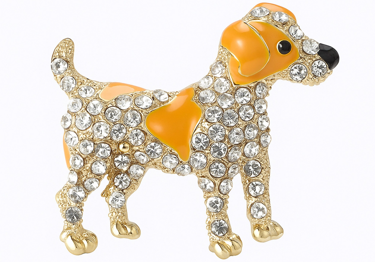 Dog brooch featuring orange enamel spots, clear faceted stones, and gold-tone metal, cutout on white background. Landscape crop for secondary use.
