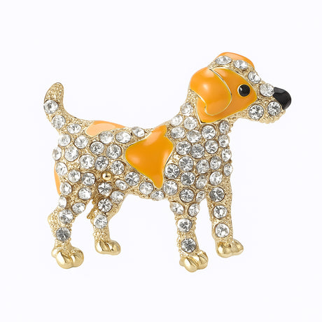 Dog brooch featuring orange enamel spots, clear faceted stones, and gold-tone metal, cutout on white background.