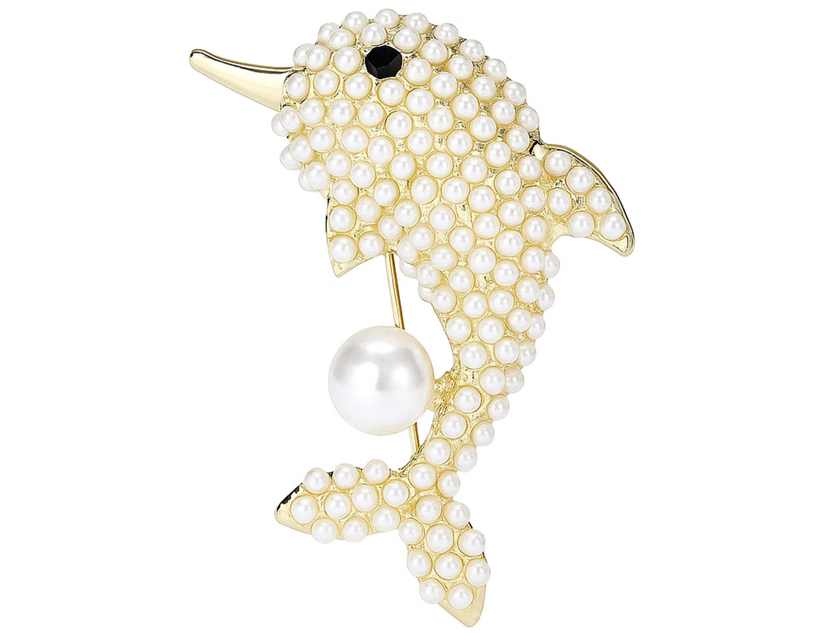 Dolphin brooch with gold-tone metal finish, white round beads, black stone eye, and large hanging faux pearl, cutout on white background. Landscape crop for secondary use.