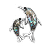 Dolphin brooch with silver-tone outline, black eyes, and vibrant multicolor inlay suggestive of faux abalone shell, front-facing cutout on white background.