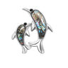 Dolphin brooch with silver-tone outline, black eyes, and vibrant multicolor inlay suggestive of faux abalone shell, front-facing cutout on white background.