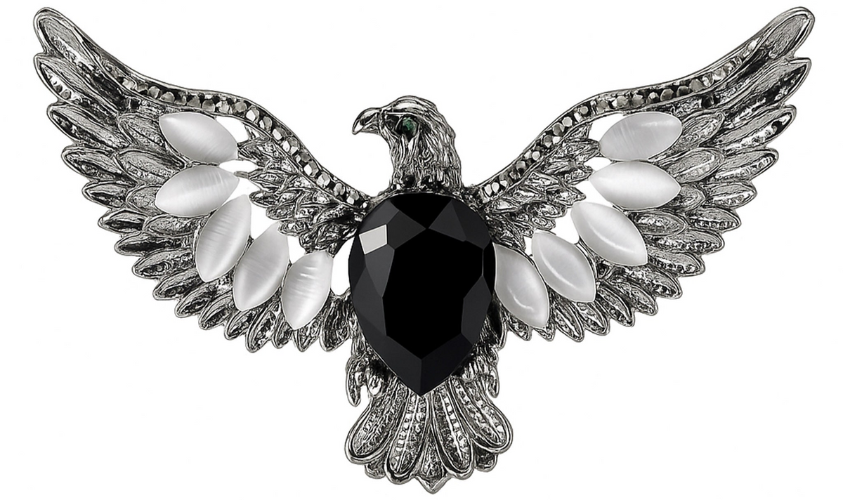 Eagle brooch with silver-tone finish, black faceted center stone, and white oval accent stones, cutout on white. Landscape crop for secondary use.