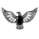 Eagle brooch with silver-tone finish, black faceted center stone, and white oval accent stones, cutout on white.