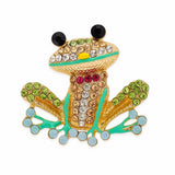 Frog brooch with gold-tone base, multicolor faceted stones, black eyes, and green enamel accents, cutout on white.