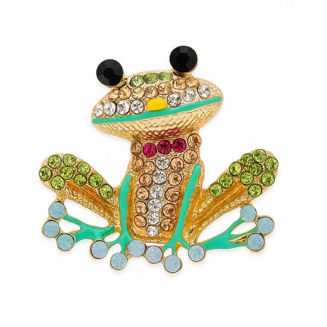 Frog brooch with gold-tone base, multicolor faceted stones, black eyes, and green enamel accents, cutout on white.