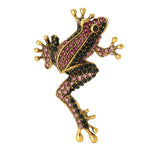 Frog brooch with gold-tone metal base, pink and black faceted stones in a climbing pose, cutout on white background.
