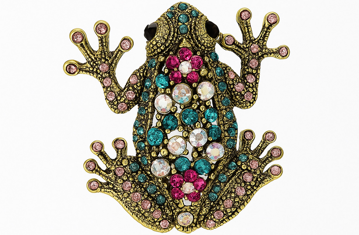 Frog brooch with gold-tone metal finish, adorned with pink, teal, and iridescent faceted stones, cutout on white background. Landscape crop for secondary use.