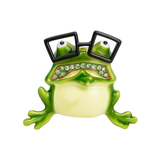 Frog brooch with green enamel body, black square glasses, and green faceted stone mouth, cutout on white.