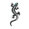 Gecko lizard brooch with silver-tone body, clear and dark faceted stones, and green-toned eyes, cutout on white background.