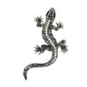Gecko lizard brooch with silver-tone metal finish, iridescent blue and purple faceted stones, and black eyes, cutout on white background.