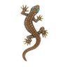 Gecko lizard brooch with bronze-tone metal finish, orange and beige faceted stones, and green eyes, cutout on white.