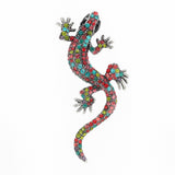 Gecko lizard brooch with multicolor faceted stones in pink, red, blue, and green tones, black eyes, cutout on white.