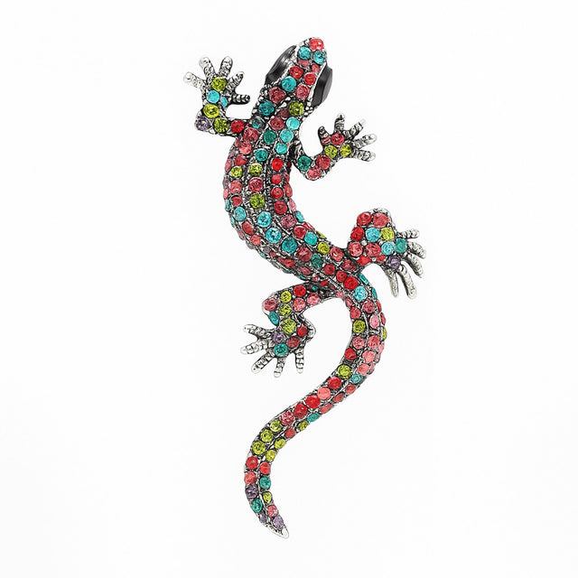 Gecko lizard brooch with multicolor faceted stones in pink, red, blue, and green tones, black eyes, cutout on white.