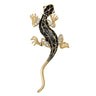 Lizard brooch with gold-tone metal finish, black enamel body with geometric pattern, and clear faceted stone accents, cutout on white.