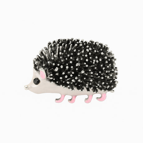 Hedgehog brooch with black and silver-tone textured spines, white body, pink legs, and black eye, cutout on white.