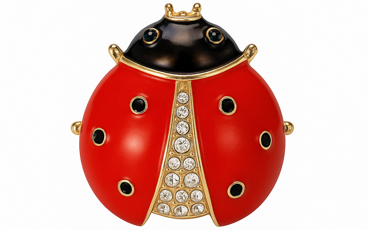 Ladybird brooch with red enamel wings, black spots, clear faceted stone center, and gold-tone metal frame. Cutout on white. Landscape crop for secondary use.