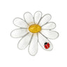 Daisy brooch with silver-tone edges, white glossy petals, yellow textured center stone, and red ladybird figure, cutout on white.