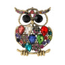 Owl brooch with gold-tone finish, multicolor faceted stones, and black round eyes, cutout on white.
